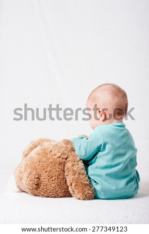 child playing with a plush toy . soft toy. funny baby with a soft toy . layout for social projects