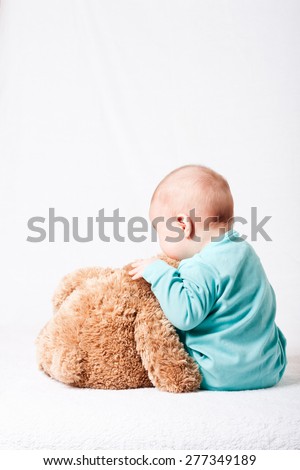 child playing with a plush toy . soft toy. funny baby with a soft toy . layout for social projects