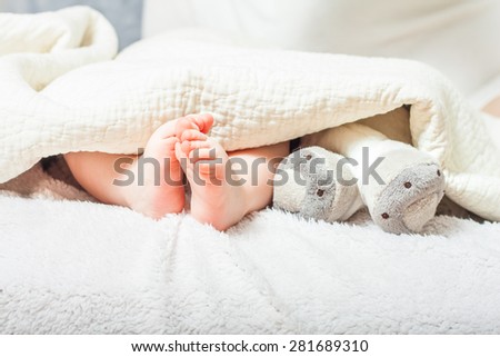 baby feet under a blanket . foot plush toys. tiny feet
