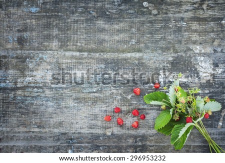 bouquet of strawberries on the board. Summer berries collected in the forest. Rural texture . Greeting Card fashion labels .