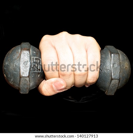 Left hand and dumbbell on black background,