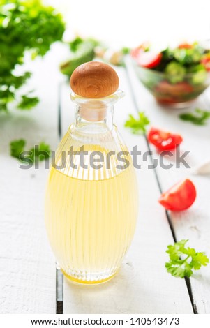 Olive oil and salad on table