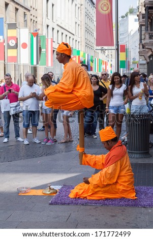 MILAN, ITALY - CIRCA AUGUST 2013: Levitating street artists on Corso Vittorio Emanuele II street in Milan
