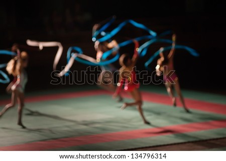 Young female gymnasts dancing with color ribbons