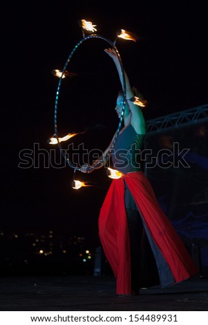 SAINT-PETERSBURG, RUSSIA - SEPTEMBER 14, 2013 : Hungarian firedancer dances with fire hula hoop on \