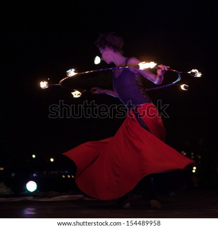 SAINT-PETERSBURG, RUSSIA - SEPTEMBER 14, 2013 : Hungarian firedancer dances with fire hula hoop on \