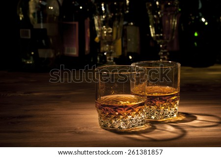 Two glasses of whiskey on a wooden table in the bar
