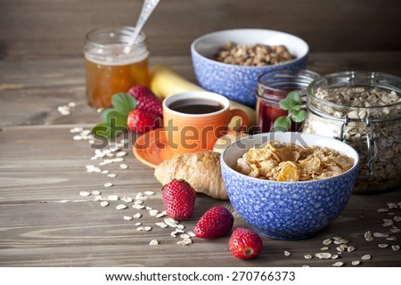 Healthy breakfast including flakes, muesli, honey, berries, jam and coffee