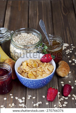 Healthy breakfast including flakes, muesli, honey, berries, jam
