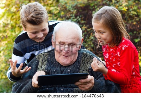 Grandfather trying hard to learn to use a tablet.
