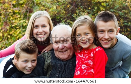 Grandchildren visiting grandfather, giving him a happy moment.
