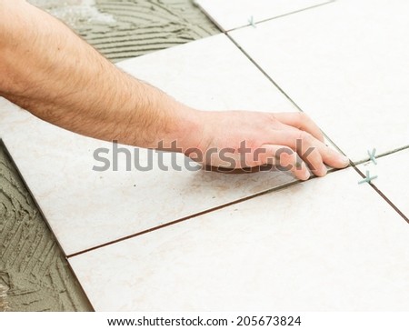 Handyman doing renovation works - floor tiling.
