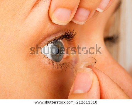 Close-up of woman removing her soft contact lenses.