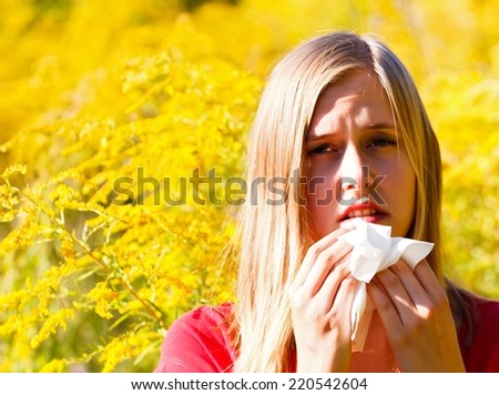 Snuffling young woman because of pollen allergy.