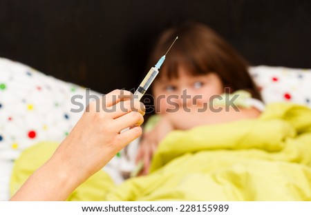 Little patient being afraid of needle, does not want to take her treatment.