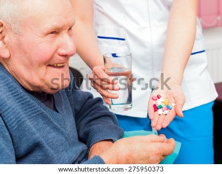 Smiling senior man taking daily treatment at the nursing home, being happy about it.