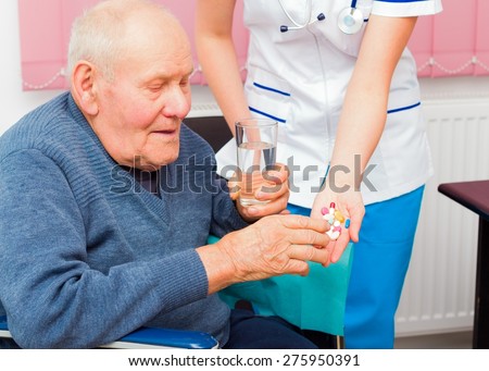Hospital services for elderly in wheelchair, young nurse helping senior patient.