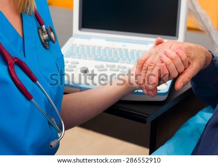 Kind doctor giving supporting hand for elderly man with serious disease.