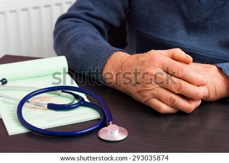 Elderly health insurance concept - close-up of the wrinkled hands of an old man .