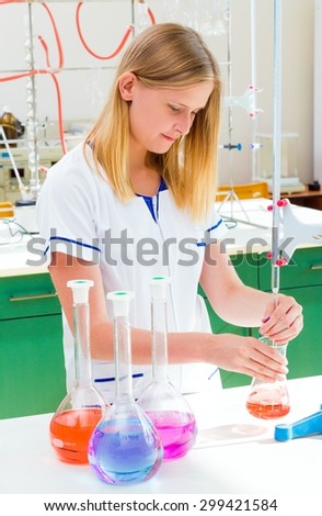 Young chemist doing scientific research, analyzing  new substances with chemical reactions.