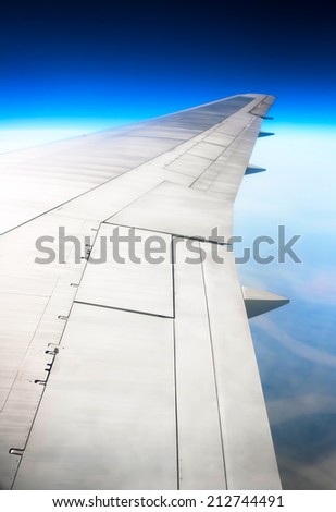 Airplane wing in deep blue sky
