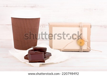 chocolate bars on white craft paper with coffee cup and craft box on background. Vintage retro