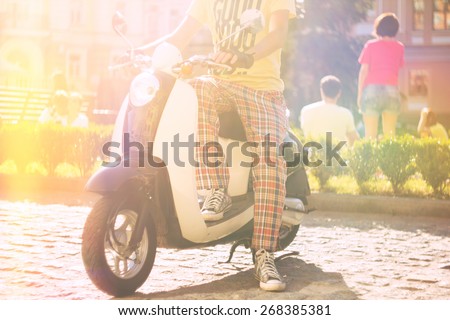 Man on retro scooter motorbike. Vintage city background