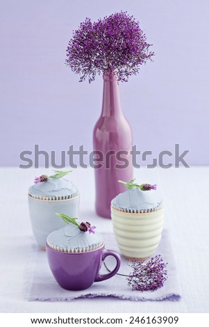 Three lavender cupcakes with a sea lavender flower in a vase