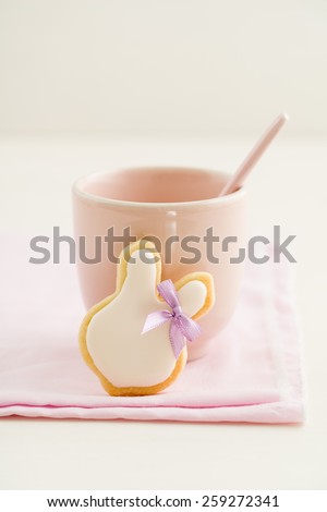 Easter bunny sugar cookie with hair ribbon and a pink cup