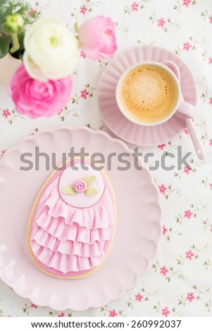 Big Easter eggs sugar cookie with fondant rose and pink ruffles, flower and a cup of coffee