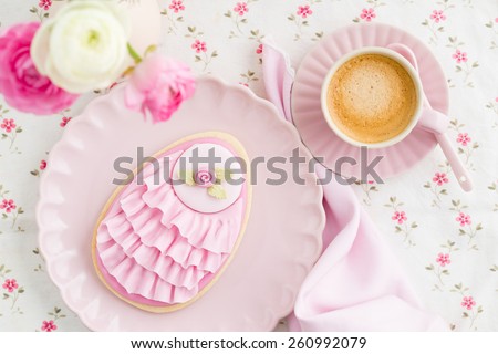 Big Easter eggs sugar cookie with fondant rose and pink ruffles, flower and a cup of coffee