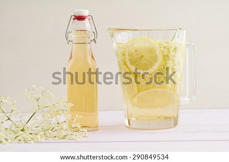 Elderflowers, sugar and lemon slices in a bottle for making elderflower syrup