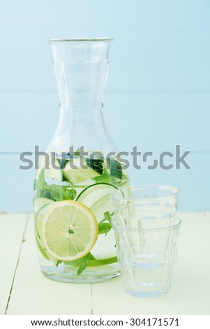 Infused water with cucumber, lemons and mint in a pitcher