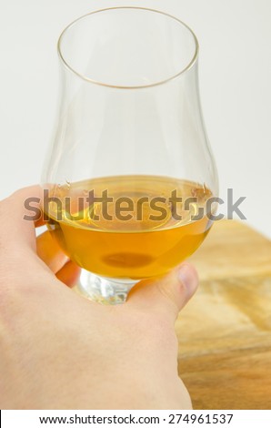 Single Malt Scotch Whisky held in hand inside Glencairn Glass