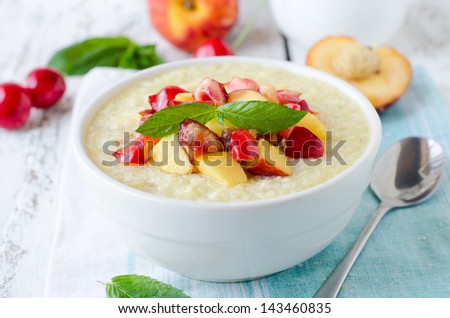 Milk porridge with peaches and cherries. Selective focus