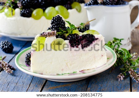 Cheesecake with blackberries and grapes on a wooden table old