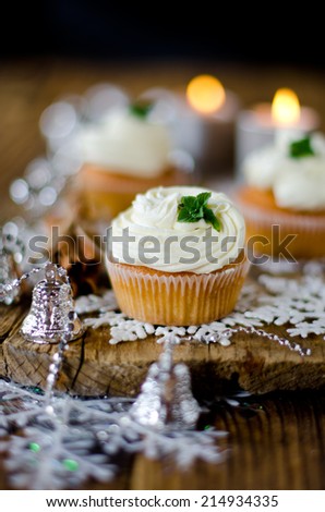 Christmas cupcakes with cream on a table decorated with Christmas decorations