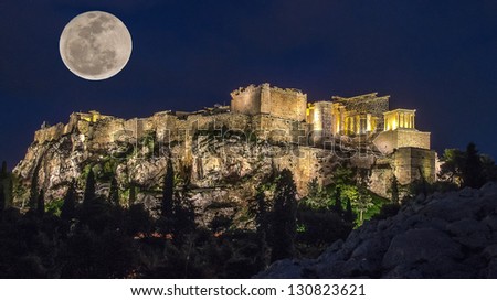 Acropolis in the moonlight. Night. The full moon and the light of lanterns light up the Acropolis. The trees in the background and lighting. In the foreground is the ancient stones in the moonlight.