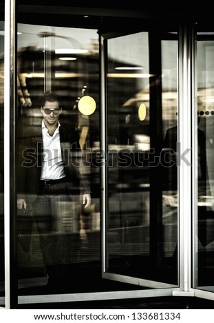 a man and revolving doors in business center