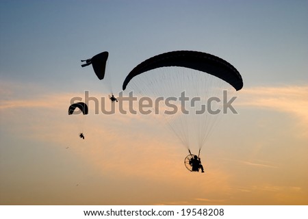 Para-motor gliders over sunset sky