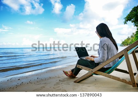 Business Woman Using A Laptop Beside The Beach