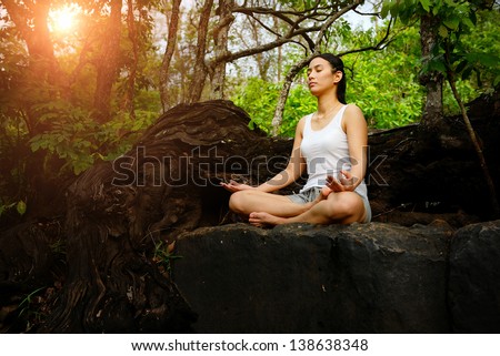 Woman Training Yoga And Meditation On The Rock At The Mountain