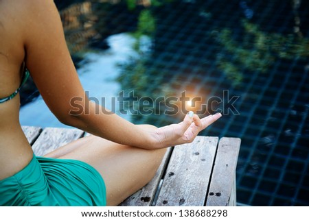 Woman training yoga and meditation at poolside, concentrate on finger