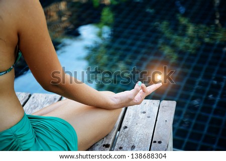 Woman training yoga and meditation at poolside, concentrate on finger