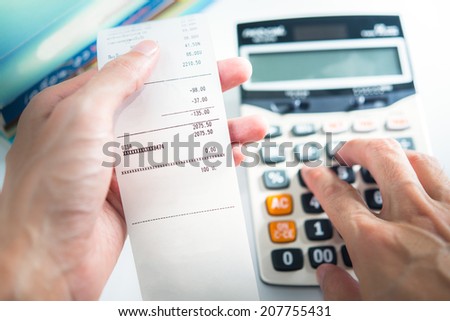 Grocery shopping list in hand with calculator - money account management concept