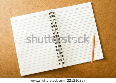 Blank spiral notebook with line paper and pencil on wood table