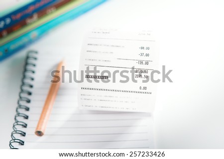 Grocery shopping list on notebook and pencil - money account management concept