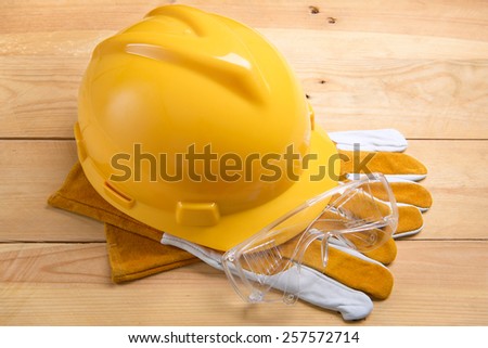 Yellow safety helmet or hard hat on wood board
