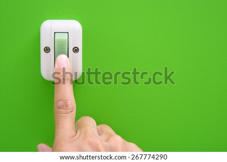 Hand turning on-off the light with wall switch