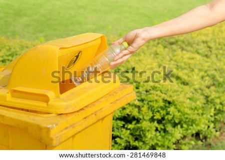 Hand throwing plastic water bottle in recycle bin